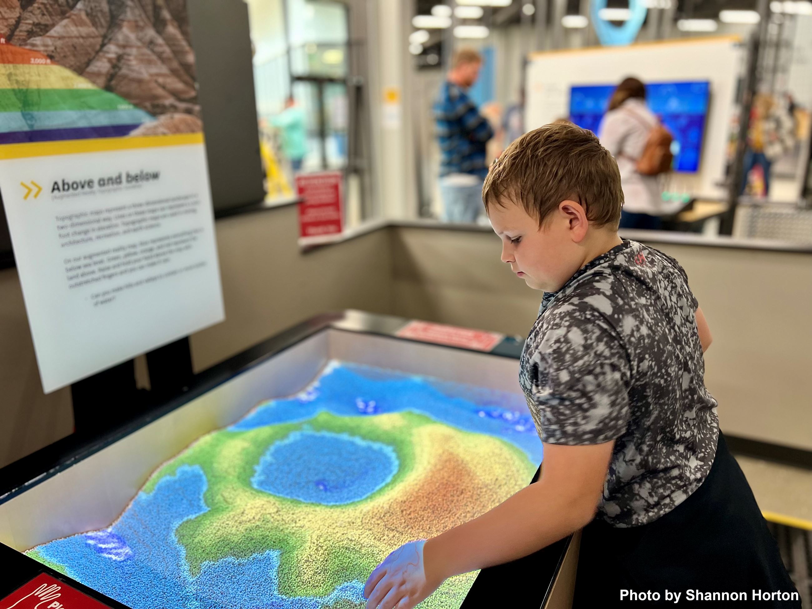 Boy playing with sand display at Gateway to Science. 