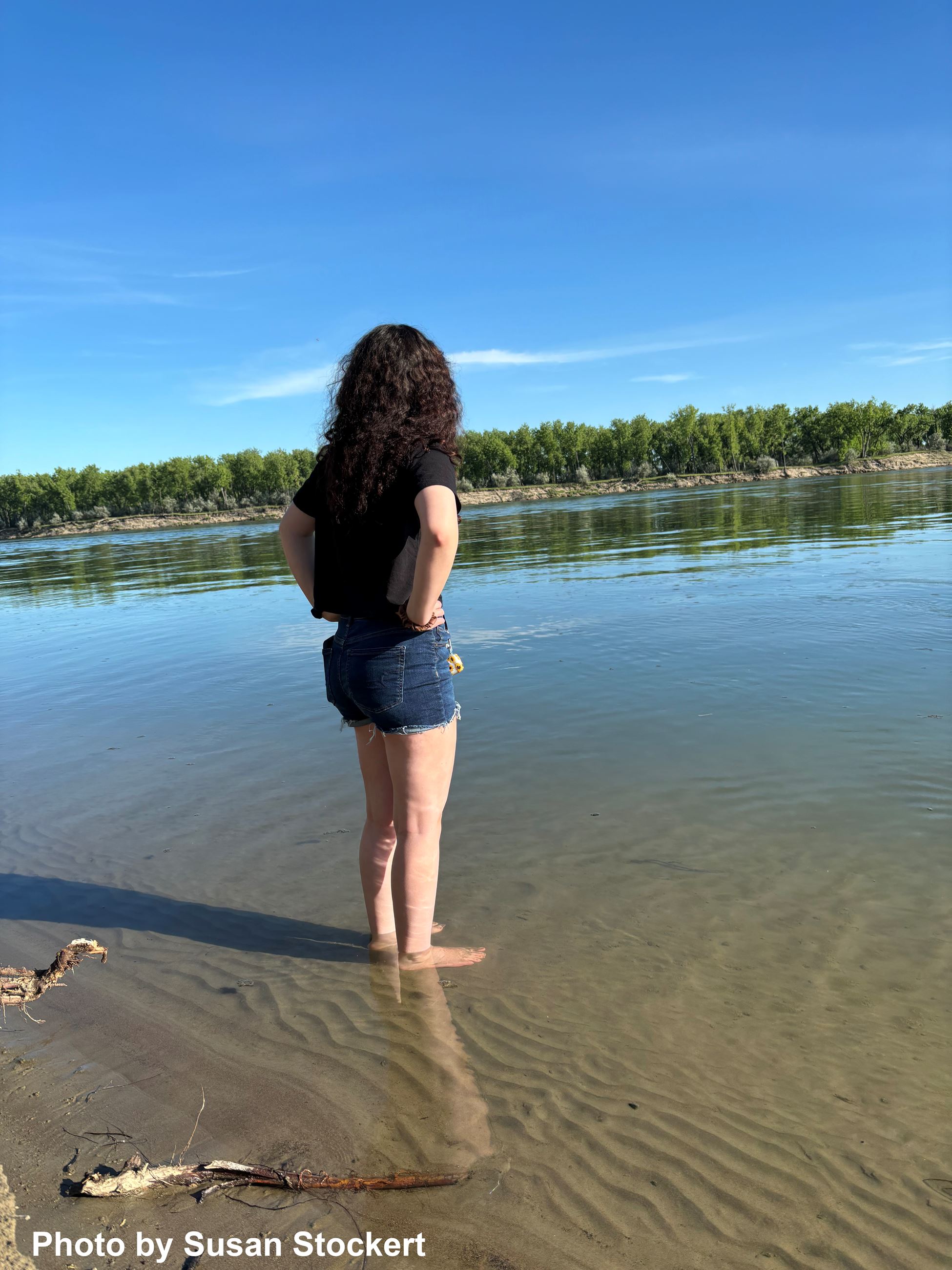 Woman standing in shallow river water. 