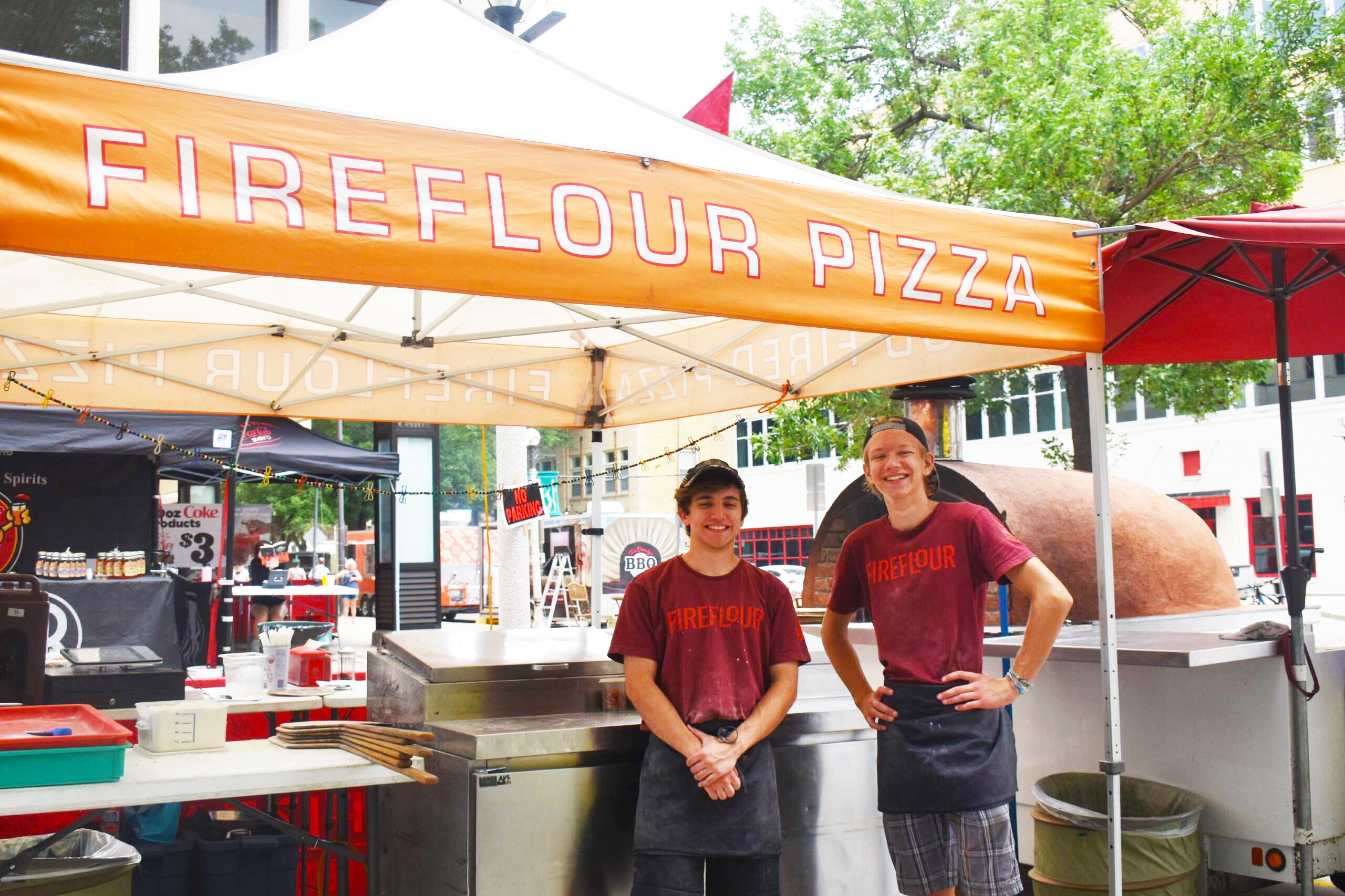 Staff from Fireflour Pizza work during the downtown street fair in Bismarck. 